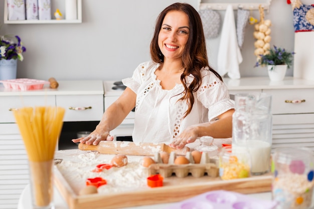 Woman preparing dough with kitchen roller