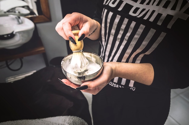 Woman preparing foam in barbershop