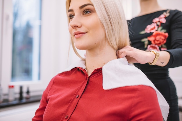 Woman preparing girl for haircut procedure