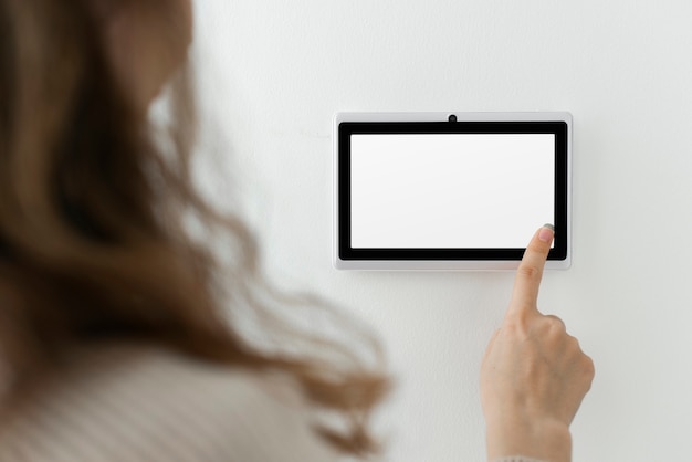 Woman pressing on smart home automation panel monitor