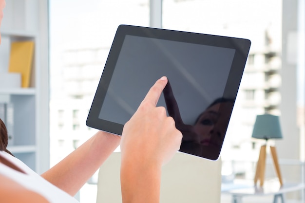 Free photo woman pressing the tablet's screen with a finger