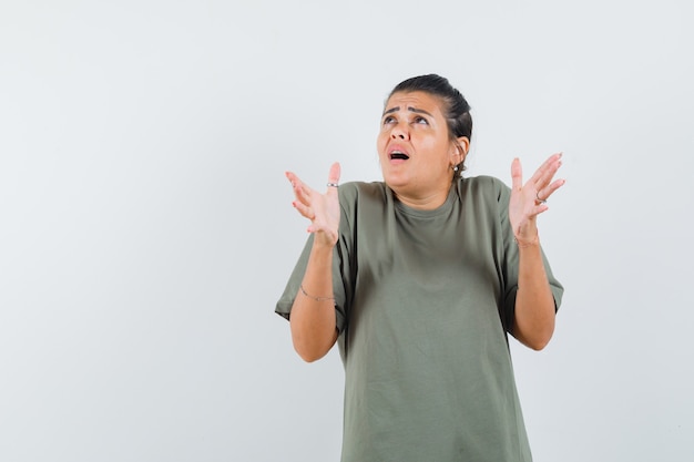 woman pretending to keep something in t-shirt and looking alarmed