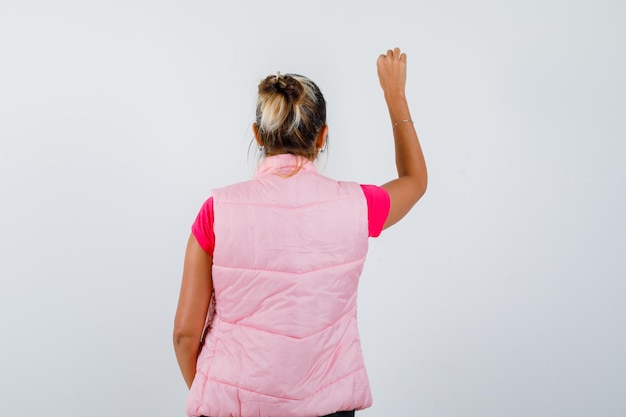 Free photo woman pretending to show something in t-shirt, vest and looking focused