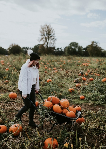 Free Photo woman at a pumpkin patch before halloween