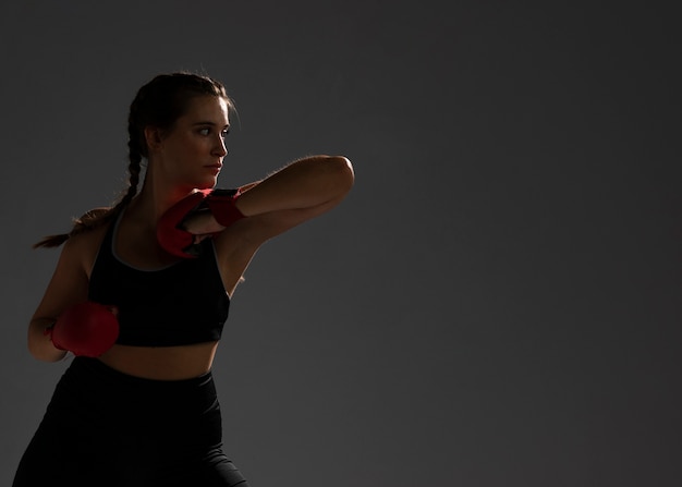 Woman punching with box gloves and copy space