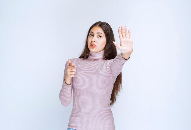 woman in purple shirt stopping something with hands.