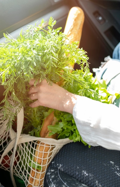 Free photo woman putting bag with groceries in car