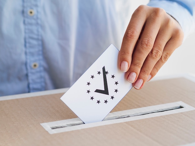 Free photo woman putting a checked european ballot in box