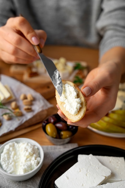 Free photo woman putting cheese on bread high angle