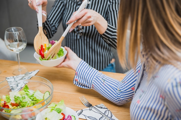 Woman putting diet food in plate