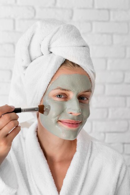 Woman putting on facial remedy close-up