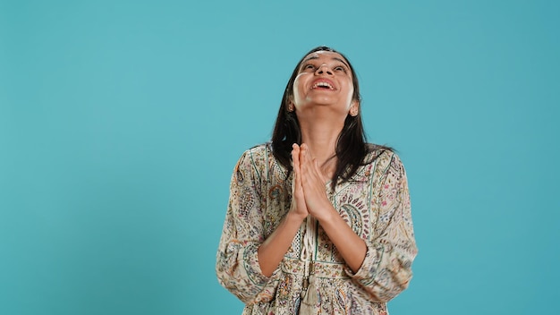 Free Photo woman putting hands together in begging gesture making wish