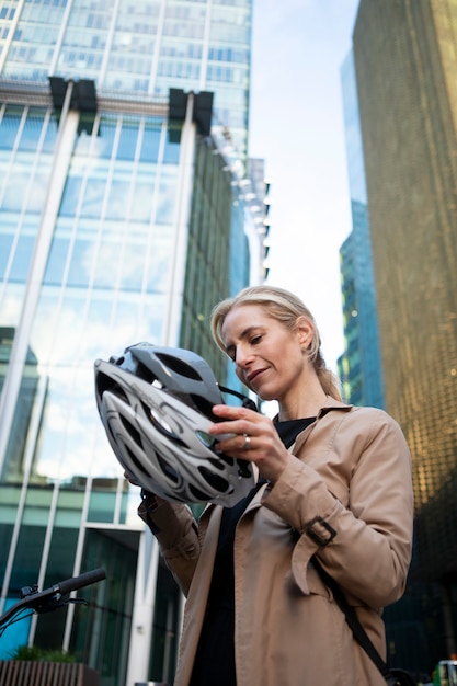 Free photo woman putting on her helmet and getting ready to ride a bike