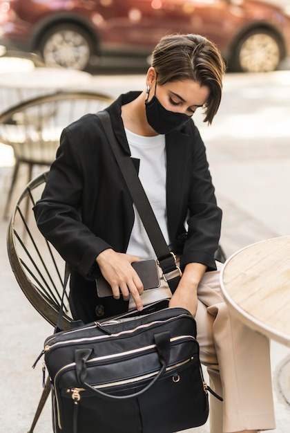 Free photo woman putting her laptop inside her purse