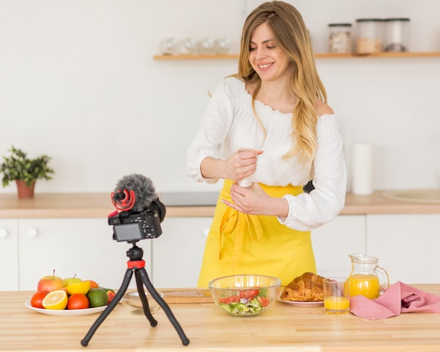 Free photo woman putting salt in salad