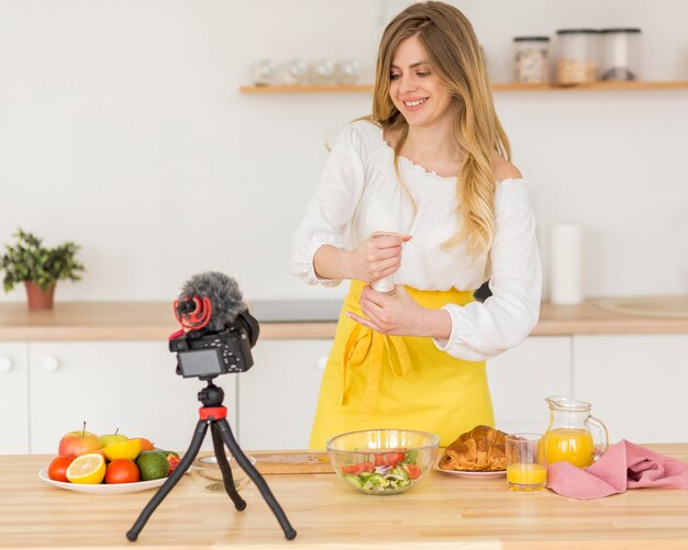 Woman putting salt in salad