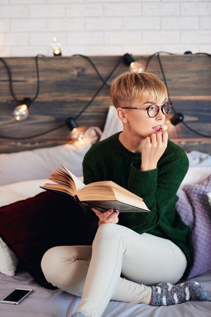 Woman reading a book in bedroom