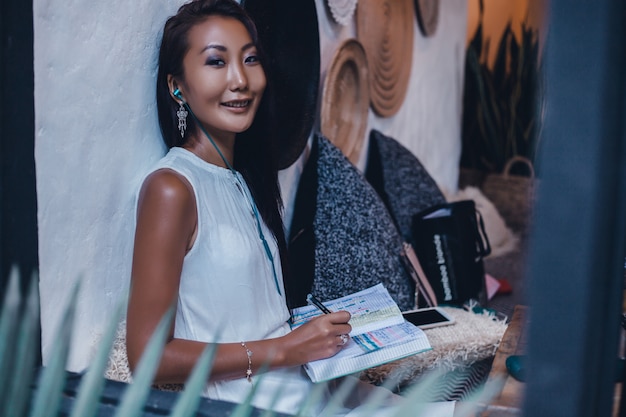 woman reading book in cafe, outdoor portrait, asian girl