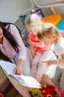 Free photo woman reading book to children