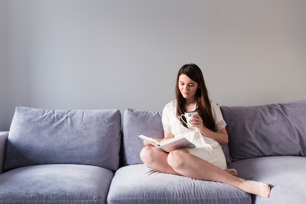 Woman reading book on couch