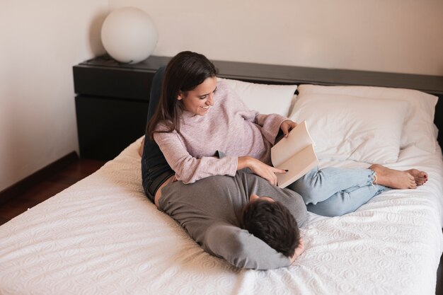 Woman reading book to husband