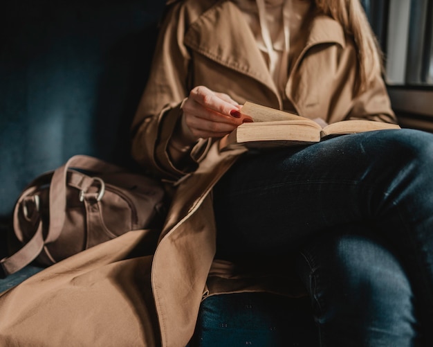 Free Photo woman reading a book inside of a train