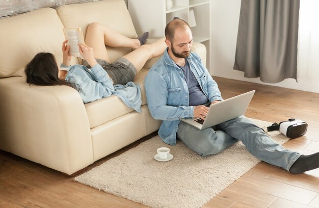 Woman reading a book laying on sofa in living room