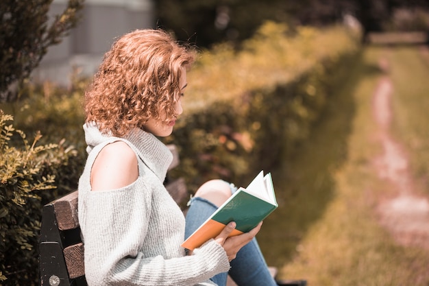 Free photo woman reading book in park