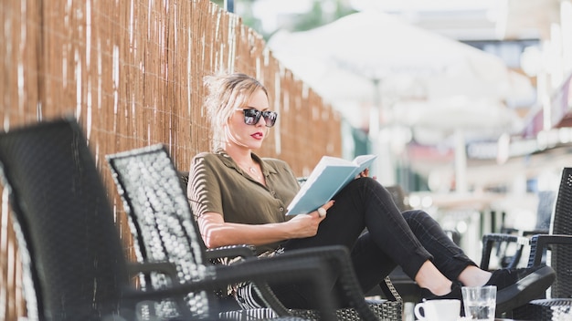 Free Photo woman reading book on resort