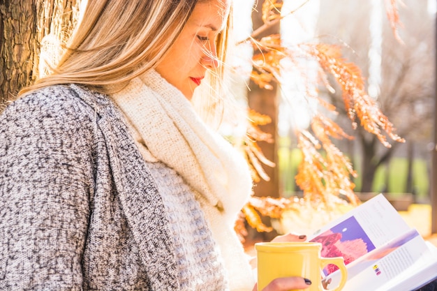 Free photo woman reading at fall surface