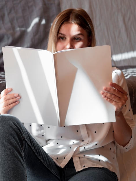 Free Photo woman reading a mock-up magazine