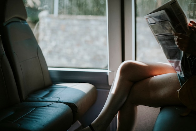 Free photo woman reading a news on a bus