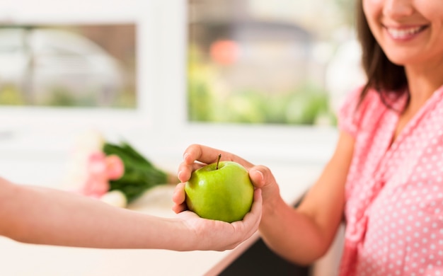 Woman receiving an apple from a kid