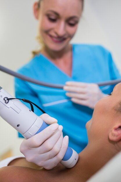 Woman receiving laser epilation treatment on her neck