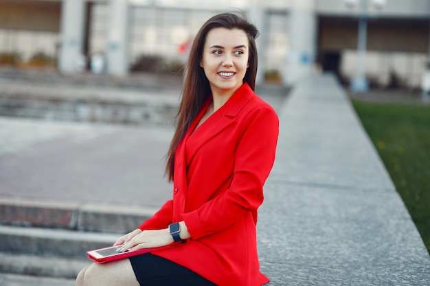 Woman in red jacket using a tablet