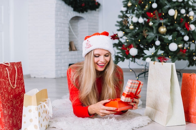 Woman in red lying on floor with gift box