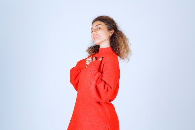 woman in red sweatshirt pointing at herself. 