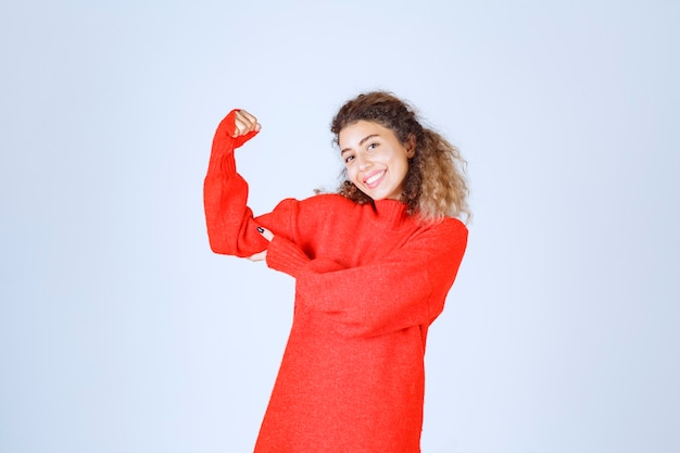 woman in red sweatshirt showing her fist and meaning her power. 