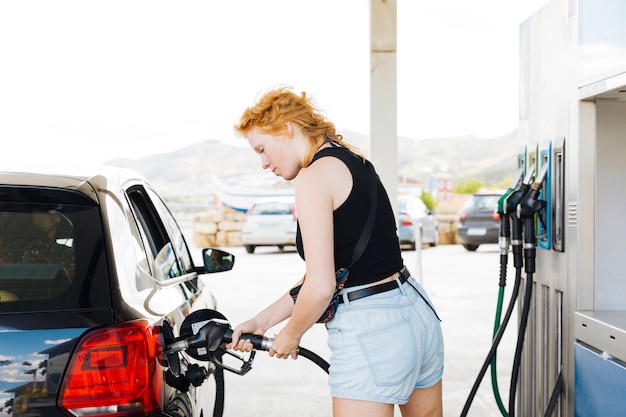 Free Photo woman refueling car with gasoline at petrol station