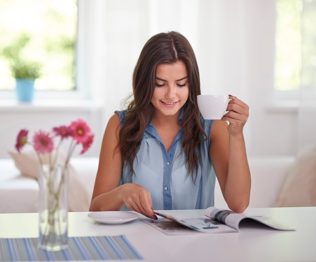 Woman relaxing with newspaper and coffee