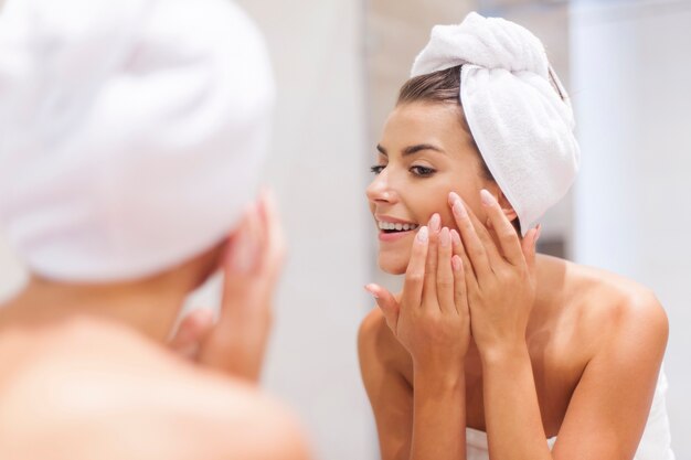 Woman removing pimple from her face