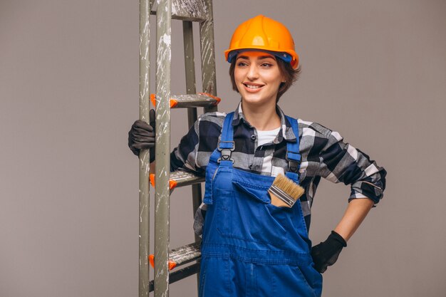 Woman repairer with ladder in a uniform isolated