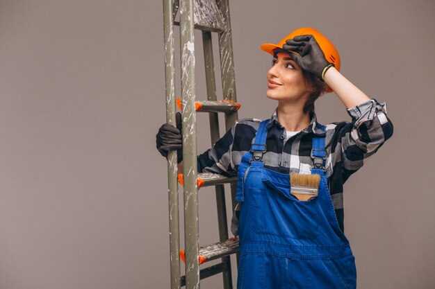 Woman repairer with ladder in a uniform isolated