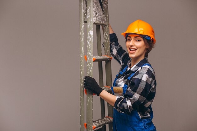 Woman repairer with ladder in a uniform isolated