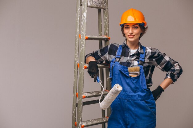 Woman repairer with ladder in a uniform isolated