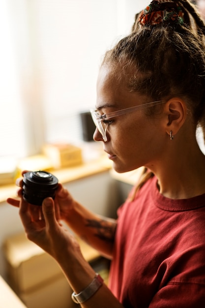 Woman repairing photo camera side view