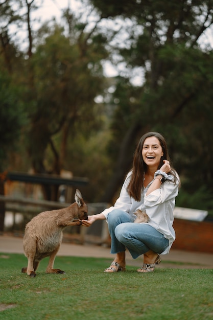 Free Photo woman in the reserve is playing with a kangaroo