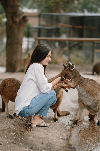 Free photo woman in the reserve is playing with a kangaroo