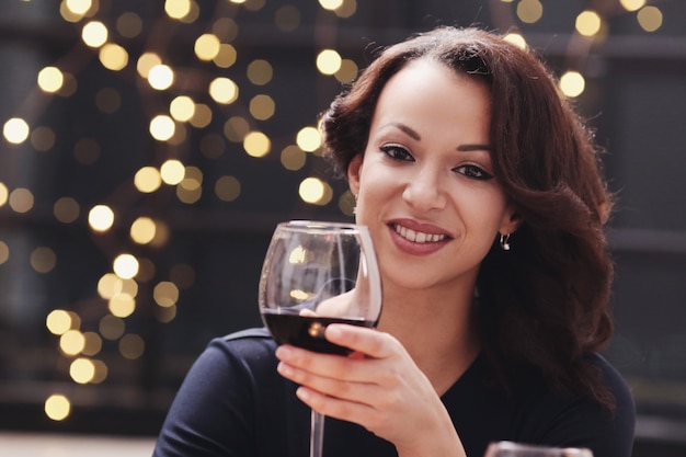 Free photo woman in restaurant holding a wine glass