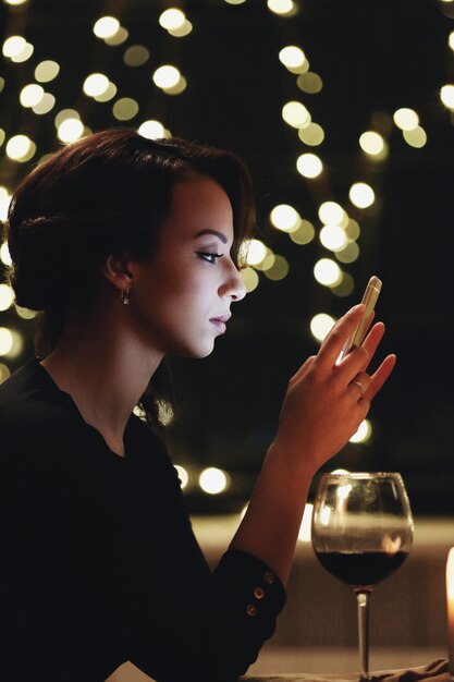 Free photo woman in restaurant using the smartphone